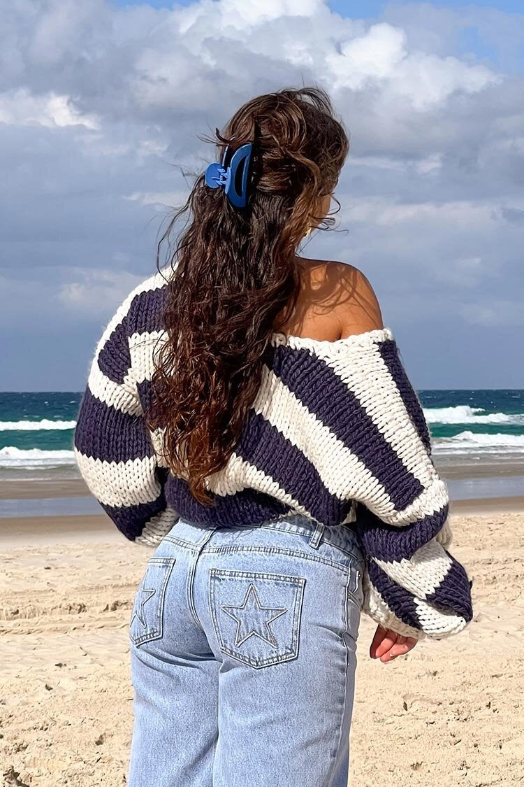 Cozy striped knit sweater with off-the-shoulder design. Chic autumn sweater. 