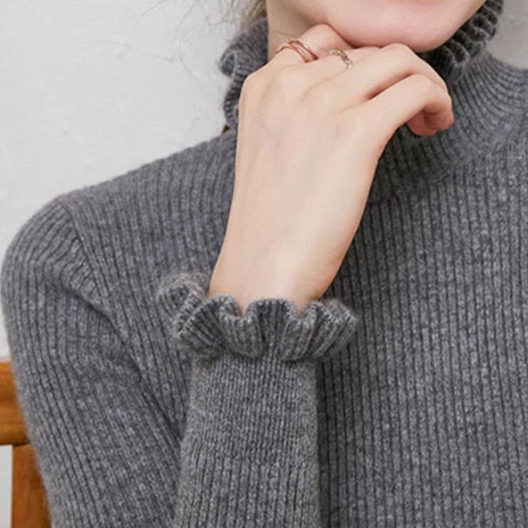 Cozy roll-neck sweater with feminine ruffle details 