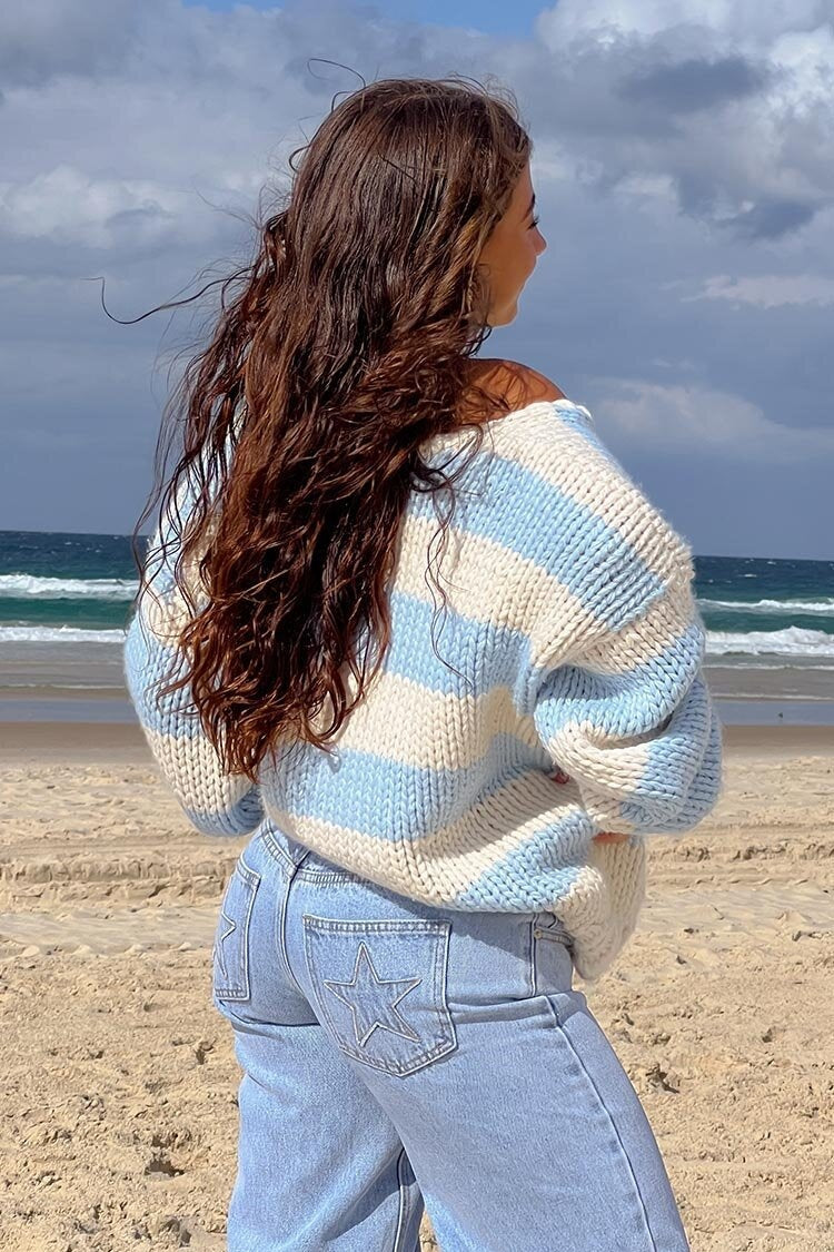 Cozy knitted sweater with an off-the-shoulder striped pattern 